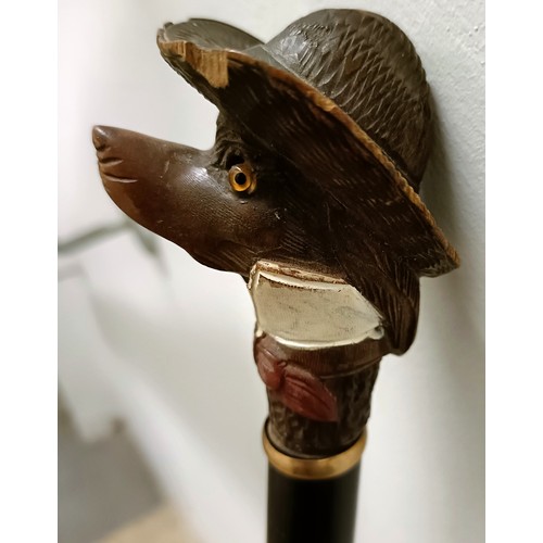 1136 - A novelty walking stick, handle carved in the form of a dog's head wearing a Stetson, with a yellow ... 