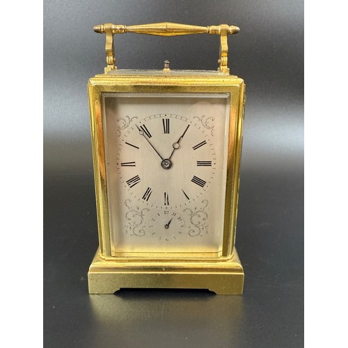 842 - A French carriage clock, with repeast, the silvered dial with alarm dial, in a brass four pillar cas... 