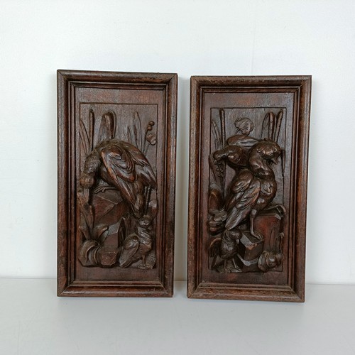 1005 - A pair of carved oak panels, decorated dead game, 48 x 25 cm (2)