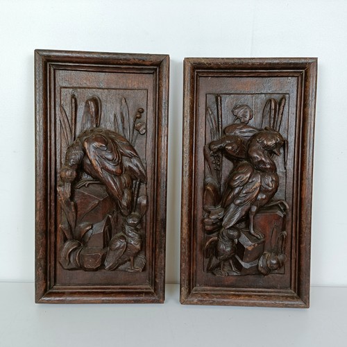 1005 - A pair of carved oak panels, decorated dead game, 48 x 25 cm (2)