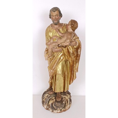 802 - A carved giltwood and polychrome group of St Joseph holding the infant Jesus, 57 cm high