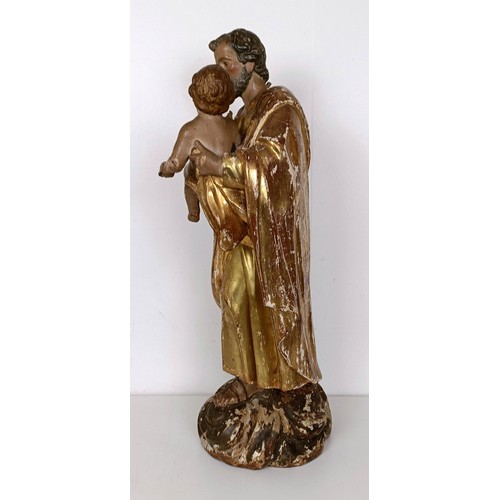 802 - A carved giltwood and polychrome group of St Joseph holding the infant Jesus, 57 cm high