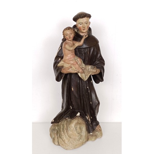 803 - A carved polychrome group of St Anthony holding the infant Jesus, 51 cm high