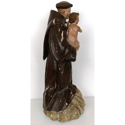 803 - A carved polychrome group of St Anthony holding the infant Jesus, 51 cm high