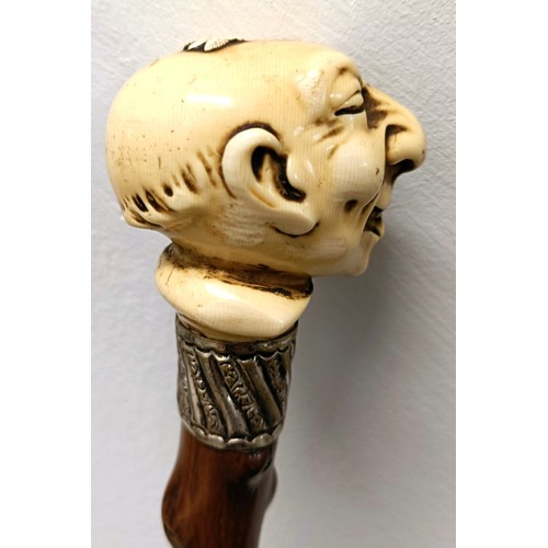 764 - A novelty walking stick, with a molded handle, in the form of a laughing man, with a silver collar, ... 