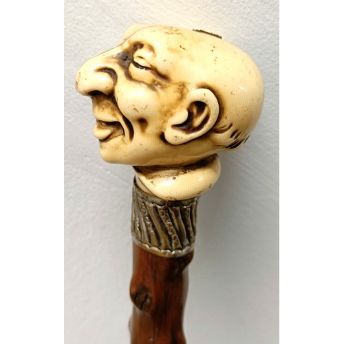 764 - A novelty walking stick, with a molded handle, in the form of a laughing man, with a silver collar, ... 