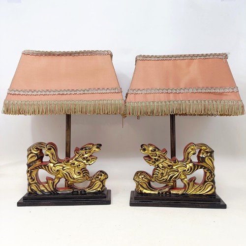 779 - A pair of carved wooden table lamps, based on the form of Dogs of Fo, 36 cm