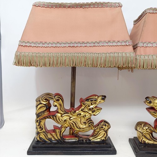 779 - A pair of carved wooden table lamps, based on the form of Dogs of Fo, 36 cm