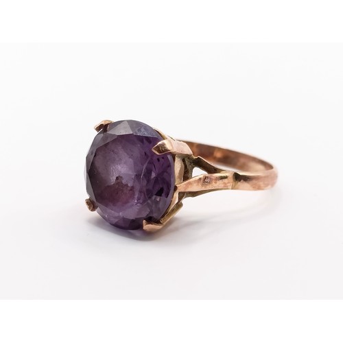740 - A vintage yellow metal and colour changing purple to blue stone ring, possibly alexandrite