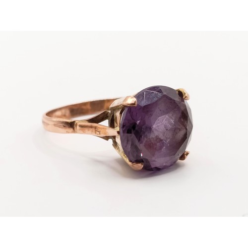 740 - A vintage yellow metal and colour changing purple to blue stone ring, possibly alexandrite
