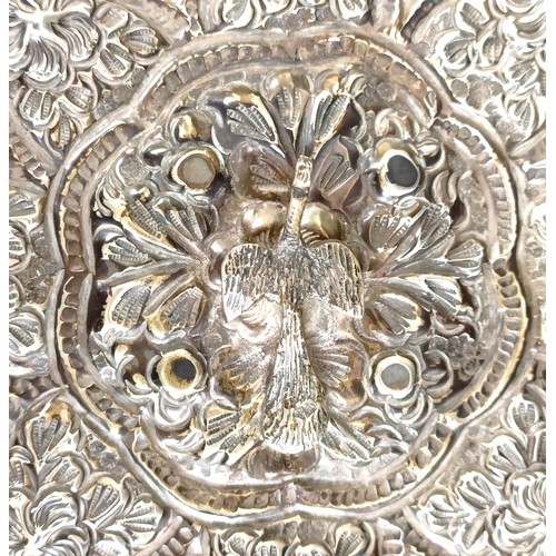 768 - An Indian silver coloured metal hand mirror, 16 cm diameter, another, decorated flowers, 22 cm wide,... 