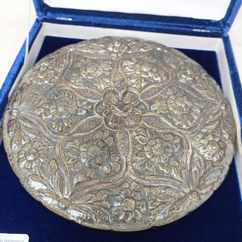 768 - An Indian silver coloured metal hand mirror, 16 cm diameter, another, decorated flowers, 22 cm wide,... 