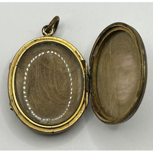 732 - A late 19th/early 20th century yellow metal memorial double locket, inset with two photographs and t... 