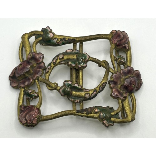 723 - A gold plated token dated 1911, with mount cut, an Art Nouveau gilt metal and enamel buckle, decorat... 
