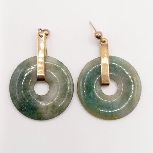 722 - A pair of yellow metal and carved green stone disc earrings, a green stone bead necklace, an opalesc... 