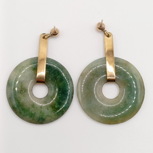 722 - A pair of yellow metal and carved green stone disc earrings, a green stone bead necklace, an opalesc... 