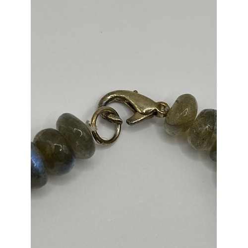 722 - A pair of yellow metal and carved green stone disc earrings, a green stone bead necklace, an opalesc... 