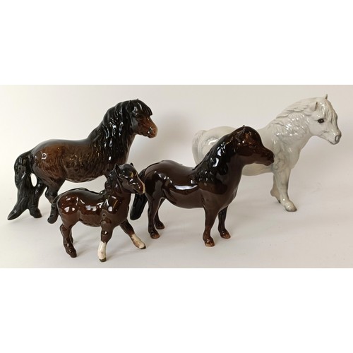 602 - A Beswick Shetland Pony, 14 cm high, another, grey, and two Shetland Pony foals (4)