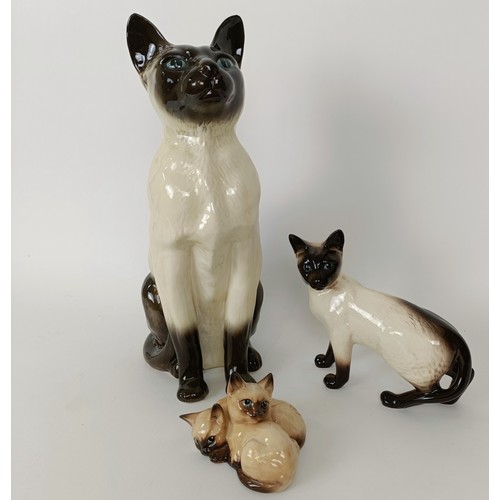 621 - A large Beswick figure of a Siamese cat, 36 cm high, and two other figures of cats (3)