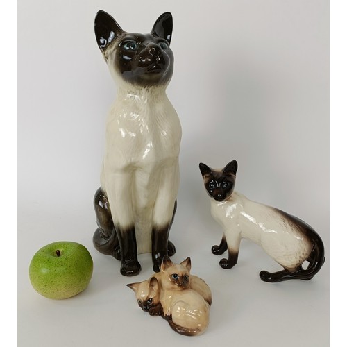 621 - A large Beswick figure of a Siamese cat, 36 cm high, and two other figures of cats (3)