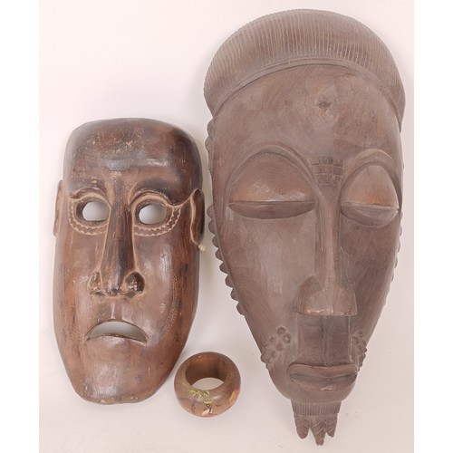 639 - A carved African mask, 40 x 20 cm and an Eastern mask, 26 x 25 cm (2)