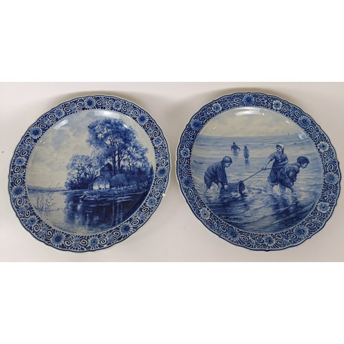 744 - A large Delft blue and white plate, decorated figures fishing, 41 cm diameter, and another, decorate... 