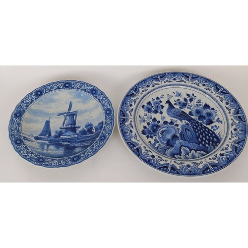 746 - A blue and white Delft plate, decorated windmill, 29 cm diameter, and another decorated peacock, 35 ... 