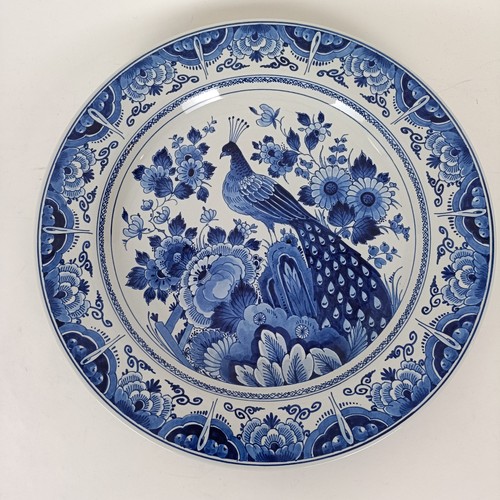 746 - A blue and white Delft plate, decorated windmill, 29 cm diameter, and another decorated peacock, 35 ... 