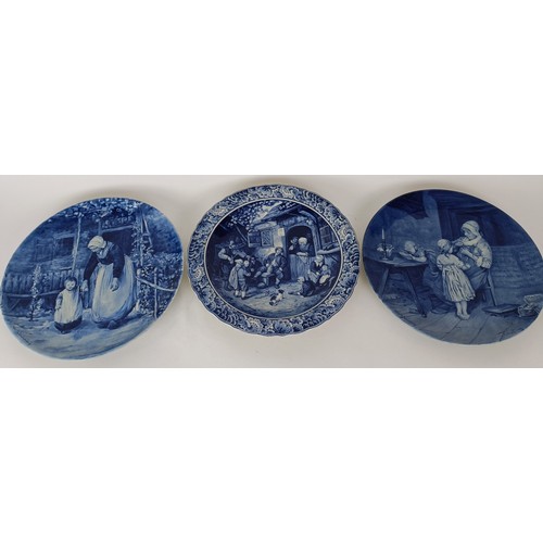 747 - A Delft blue and white plate, decorated mother and children, 34 cm diameter, another, decorated tave... 