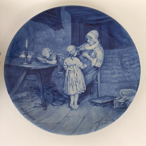 747 - A Delft blue and white plate, decorated mother and children, 34 cm diameter, another, decorated tave... 