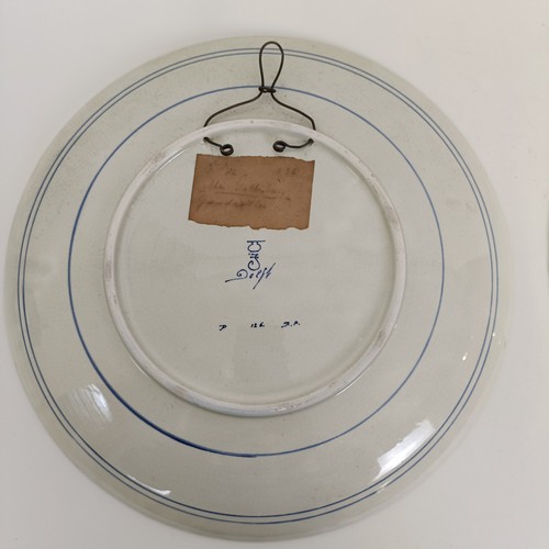 747 - A Delft blue and white plate, decorated mother and children, 34 cm diameter, another, decorated tave... 
