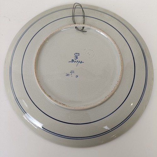 747 - A Delft blue and white plate, decorated mother and children, 34 cm diameter, another, decorated tave... 
