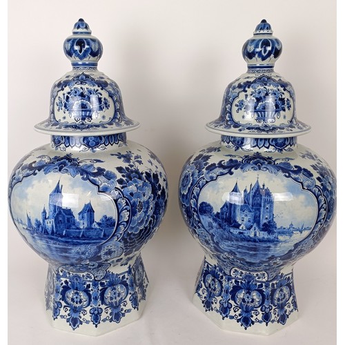 748 - A large pair of blue and white Delft vases and covers, central cartouches decorated landscapes with ... 