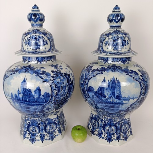 748 - A large pair of blue and white Delft vases and covers, central cartouches decorated landscapes with ... 