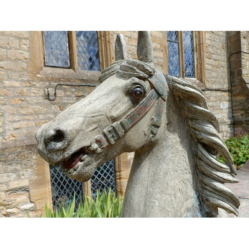 619 - A large and impressive carved wood and painted carousel horse, on a later stand, 190 cm wide
