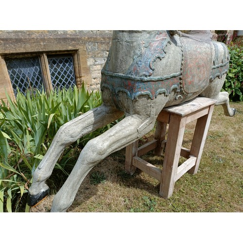 619 - A large and impressive carved wood and painted carousel horse, on a later stand, 190 cm wide