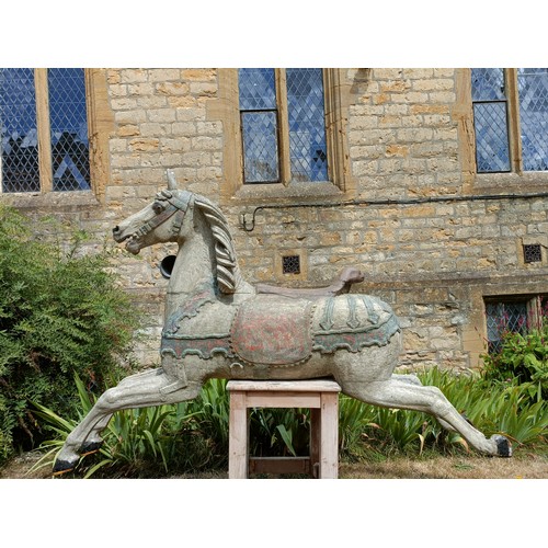 619 - A large and impressive carved wood and painted carousel horse, on a later stand, 190 cm wide