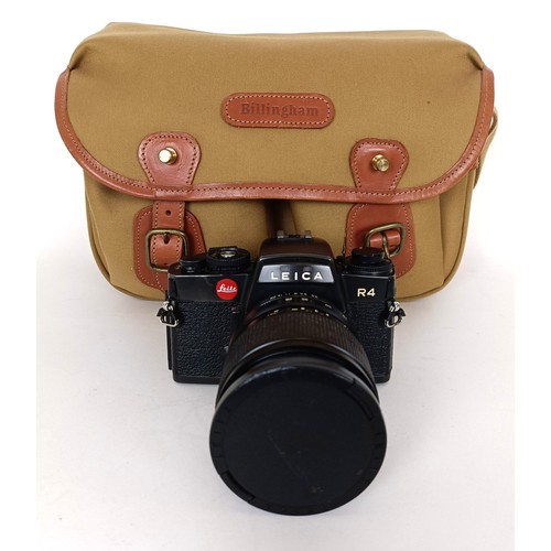 301 - A Leica R4 camera, serial number 1577161, with a Leica lens and a camera bag