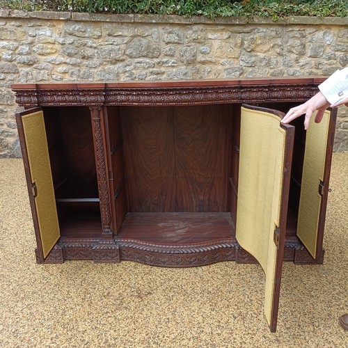 971 - A 19th century Burmese serpentine shaped front cabinet, with carved and pierced decorated and having... 