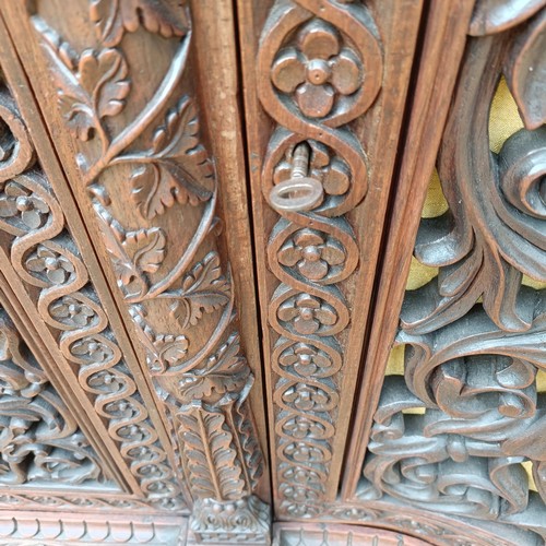 971 - A 19th century Burmese serpentine shaped front cabinet, with carved and pierced decorated and having... 