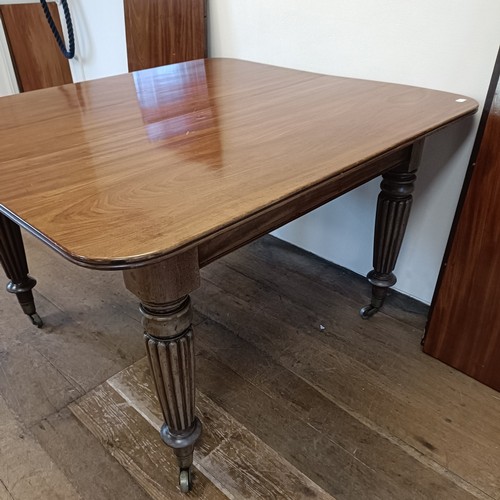 997 - A 19th century mahogany extending dining table, on turned reeded tapering legs to casters, the top, ... 