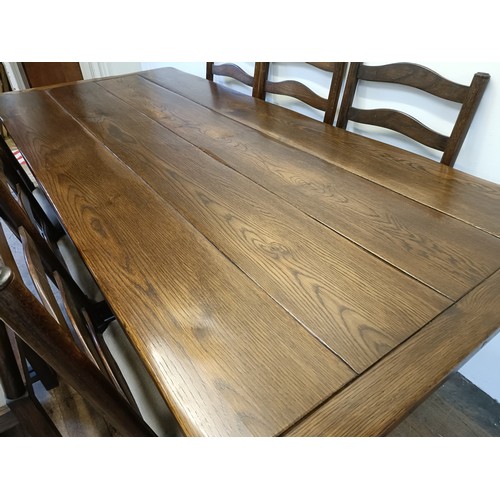 976 - An oak refectory type dining table, the top 90  x 200 cm, and a set of eight ladderback dining chair... 