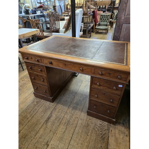 980 - A mahogany pedestal desk, of nine drawer configuration, 133 cm wide