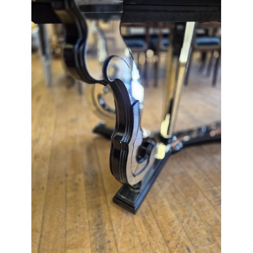 1004 - A late 20th century Italian mirrored and ebonised dining table, with scrolled supports, the top 240 ... 
