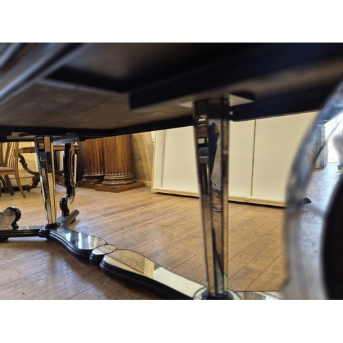 1004 - A late 20th century Italian mirrored and ebonised dining table, with scrolled supports, the top 240 ... 