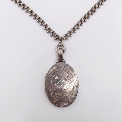 666 - An oval silver locket, decorated ferns and foliage, on a chain