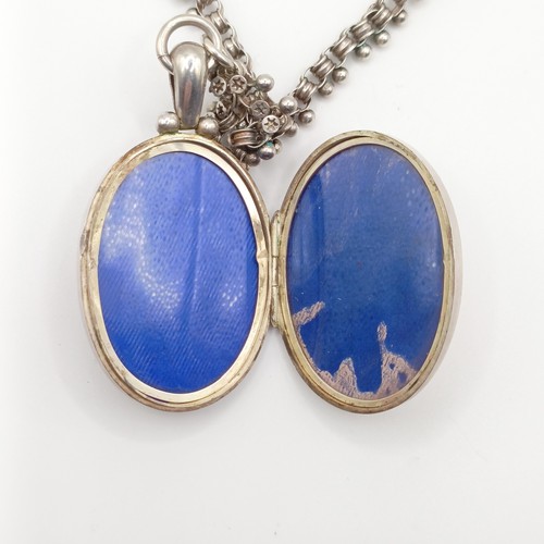 666 - An oval silver locket, decorated ferns and foliage, on a chain