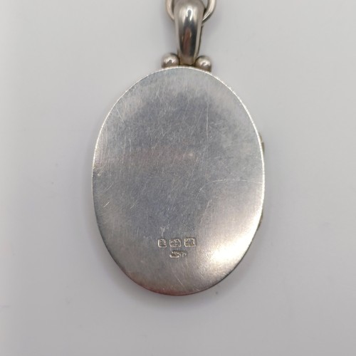 666 - An oval silver locket, decorated ferns and foliage, on a chain