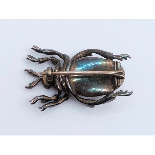 684 - A late 19th/early 20th century silver coloured metal and red paste bug brooch