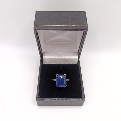 695 - A silver coloured metal and synthetic sapphire ring
